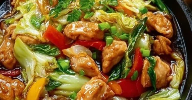 Chinesische Hähnchenpfanne mit Spitzkohl und Zwiebel auf einem Teller serviert