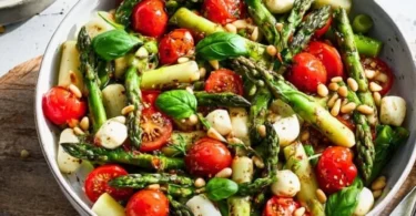 Grüner Spargel Salat mit Tomaten und Mozzarella in einer bunten Schüssel