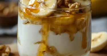 Joghurt mit Honig, Banane und Walnüssen in einer Schale serviert.