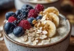 Bunte Joghurt-Porridge-Schüssel mit frischen Früchten und Nüssen